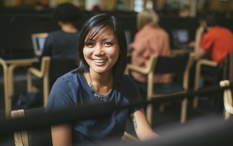 Glad student sitter i biblioteket. Foto: Niklas Björling