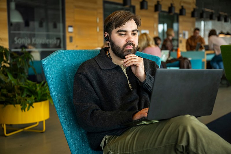 Manlig student framför sin dator i Studenthuset.