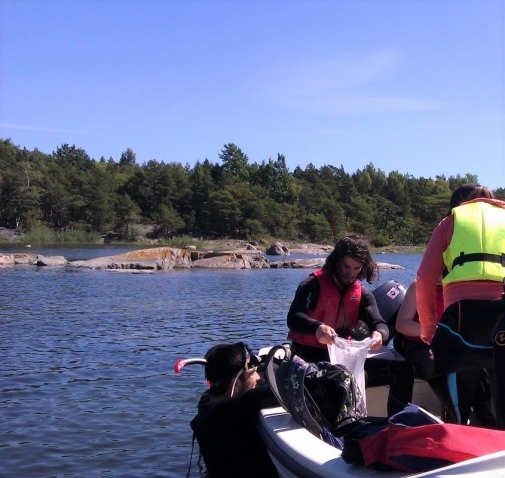 Picture 1. A snorkeller delivers a sample to the boat in Idkroken. The contents of the sample will later be picked through in the lab and all species identified and counted.
