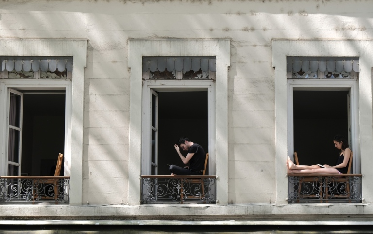 Utegångsförbud i Lyon Frankrike i maj 2020. Personer sitter i fönster på hyreshus.