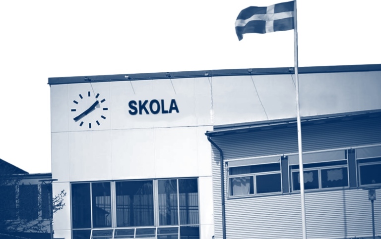 Del av omslaget till avhandlingen där fasaden på en skola syns och en svensk flagga