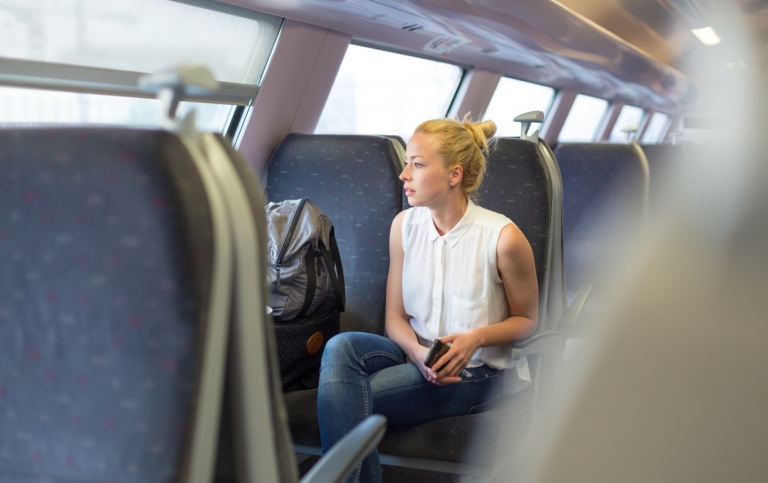En ung kvinna reser med tåg.