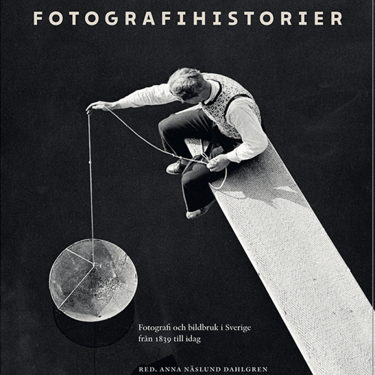 Omslaget till boken Fotografihistorier. Bild på en man som sitter på en planka och sänker ner kärl.