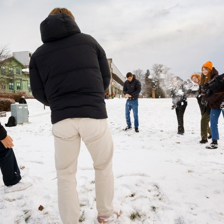 Students throwing snowballs on campus.