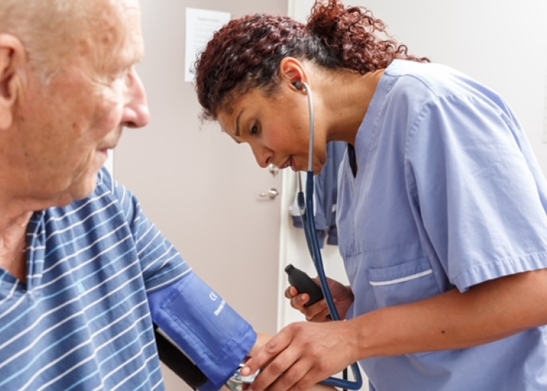Sjukvårdare tar hand om pensionär