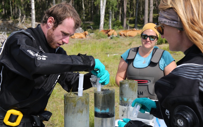 Expeditionsdeltagare hämtar prover ur sedimentkärnor från viken vid Askö.