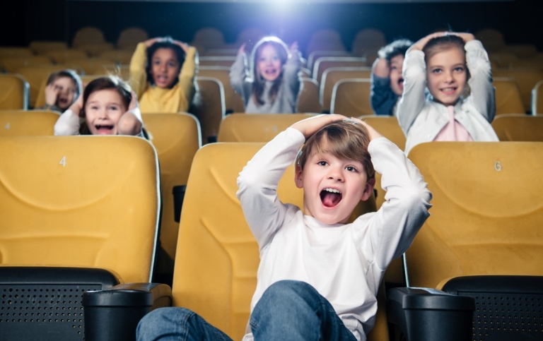 Barn sitter i bilsalong och ser på film
