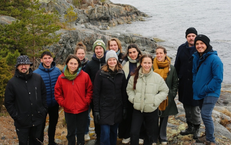 Students standing by the shore. The Baltic Sea in the background.