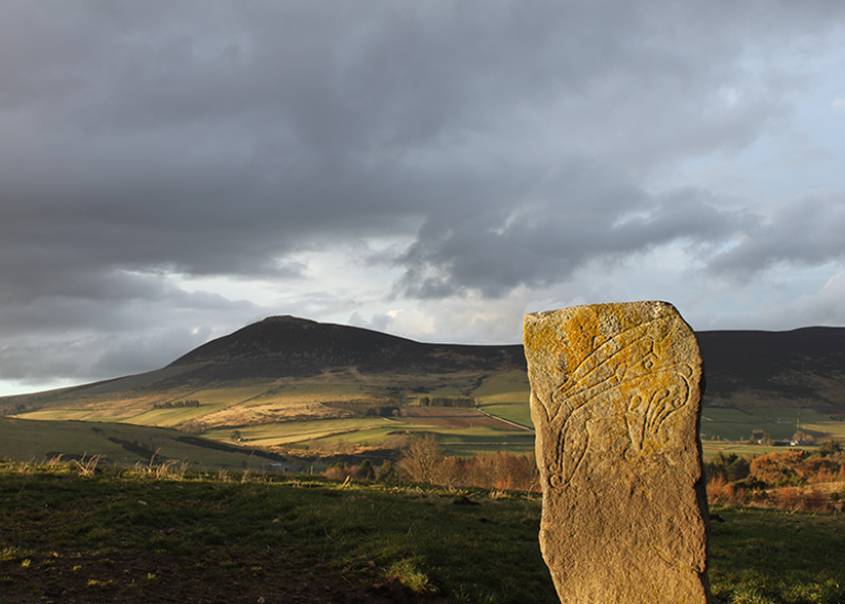 The Craw Stane Symbol Stone (foreground) and Tap o’Noth hillfort