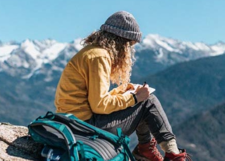 En läsande student på en bergstopp