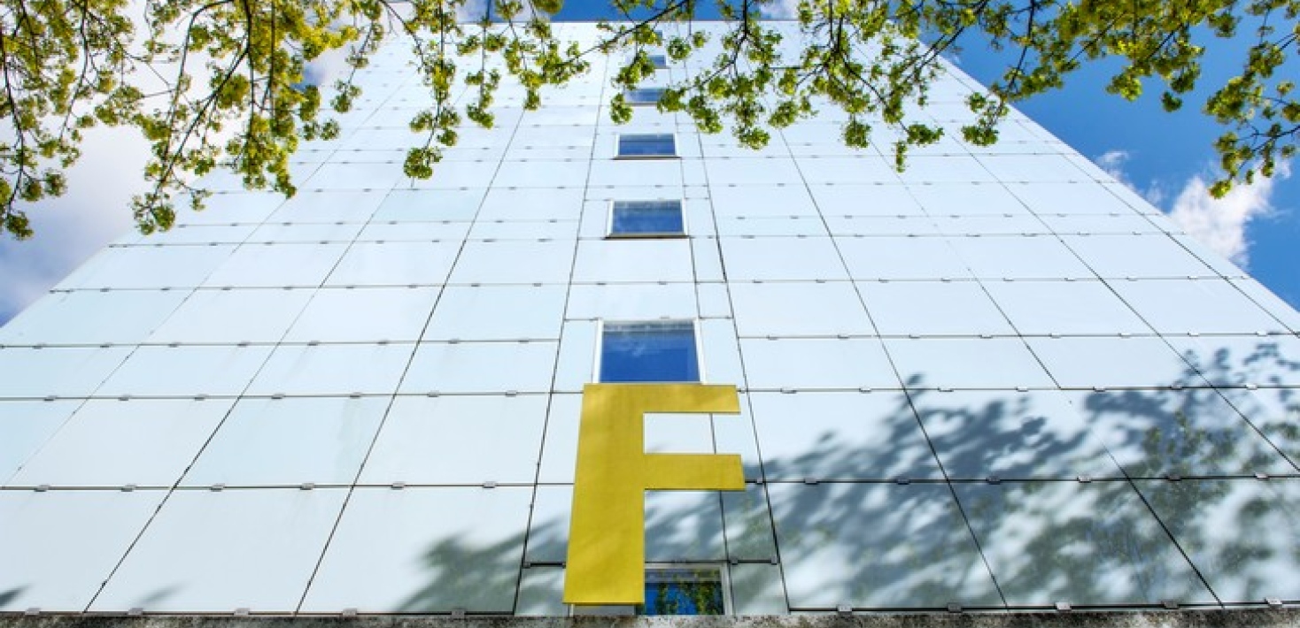 Bild på bokstaven F som sitter ovanför en ingång till ett höghus.