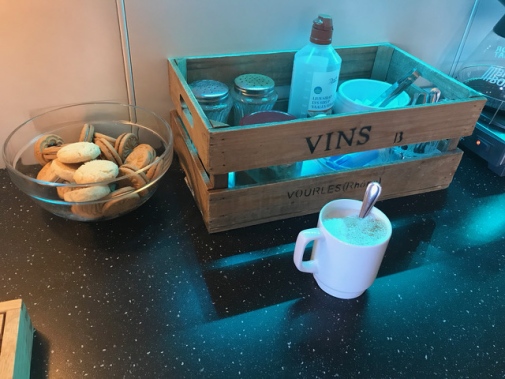 bowl of cookies and a little crate with cups, sugar, sirap etc