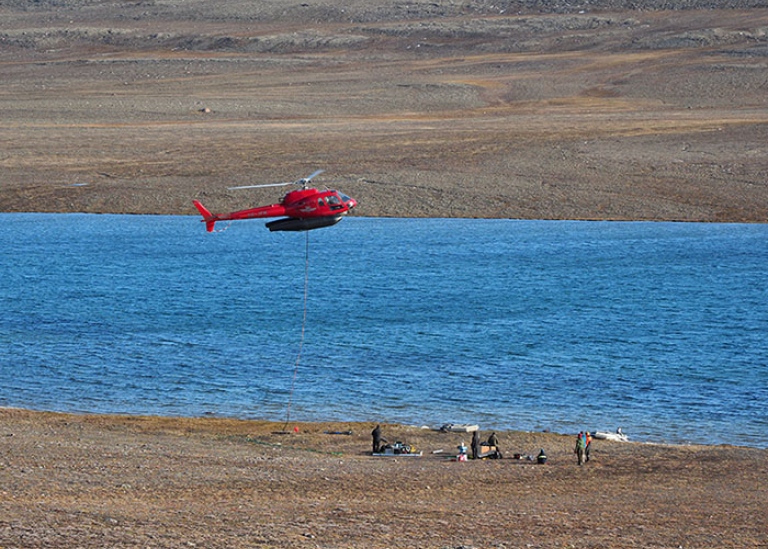 helicopter placing the corer on a wooden pallet after coring on lake