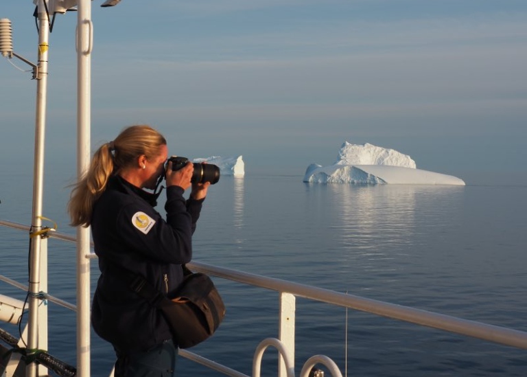Sara Johansson, the expedition's meteorologist, photographing icebergs off Thule, Greenland.
