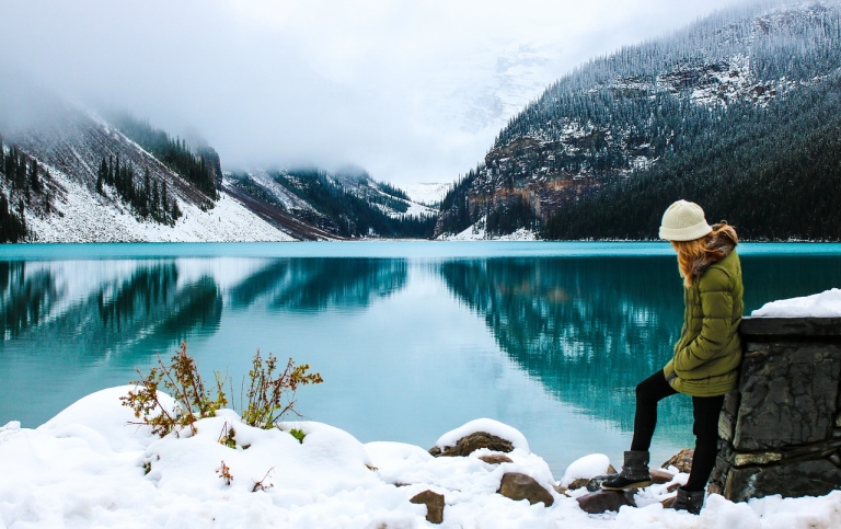 Woman in snow by a lake. Photo: Olya Adamovich from Pixabay.