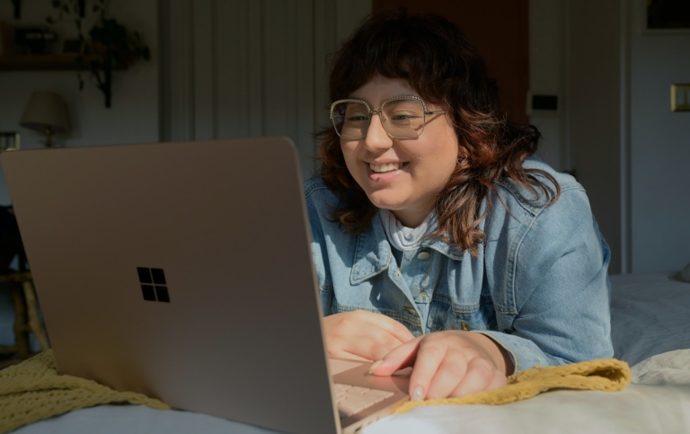 Glad ung kvinna med laptop