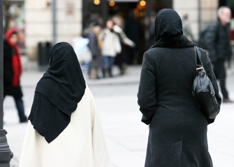 Två kvinnor med slöja promenerar i stadsmiljö. Foto: Unsplash