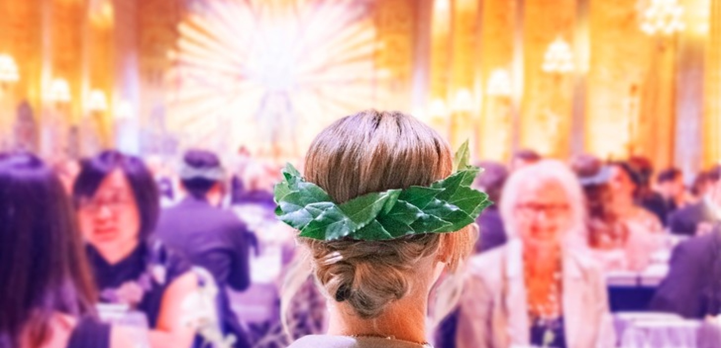 Woman seen from behind at banquet, wearing a bearing wreath