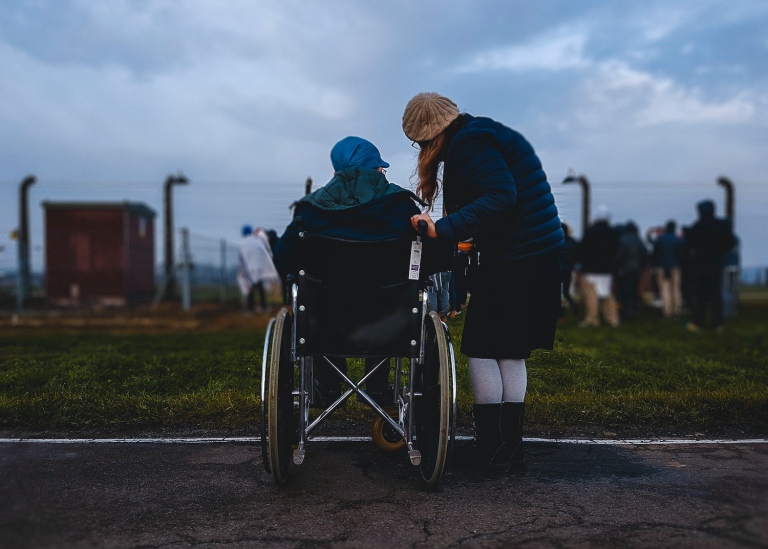Två personer, varav en i rullstol  