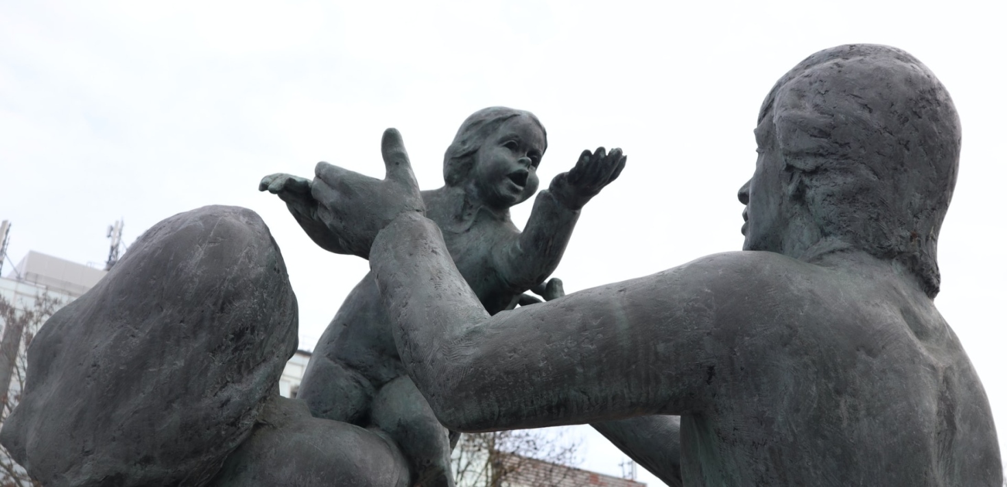 Statues of adults arguing over a child.