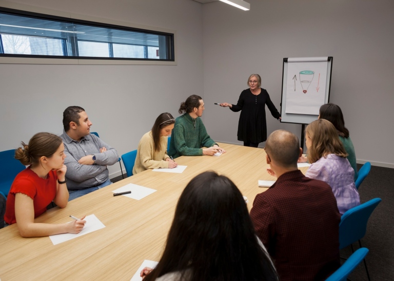En företagssköterska ger en föreläsning till en grupp studenter.