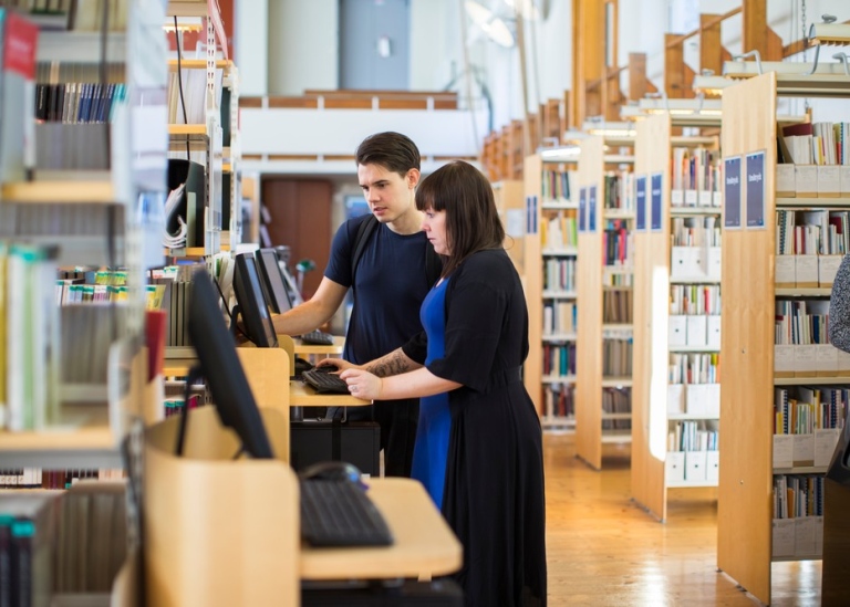 Students searching on a computer in a library