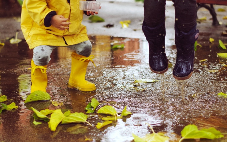 Genre photo: children playing in the rain. Photo: Xavi Cabrera/Unsplash.