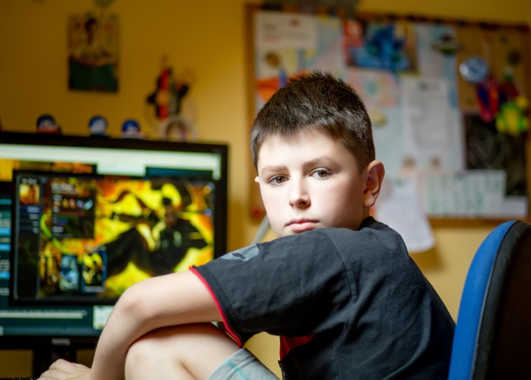 Pojke sitter hemma framför en dataskärm