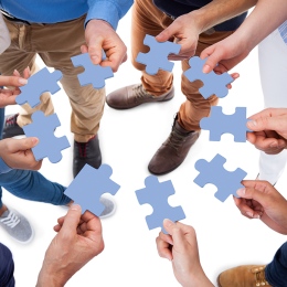 Genre photo: A group of people holding blue puzzle pieces. Photo: Andrey Popov/Mostphotos.