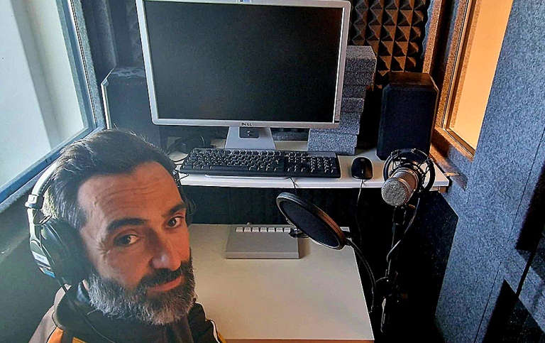 Director of the Multilingualism Laboratory, José Alemán Bañón. Photo: Pia Nordin. José with headphones looking up at the camera. Computer screen and mike in the background.