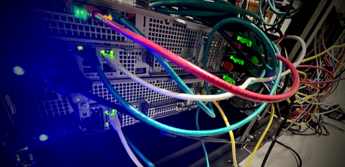 The back of a server with cables in different colors and flashing lights
