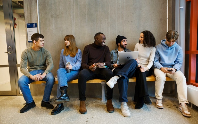 Grupp av studenter sitter på en bänk. Foto: Jens Olof Lasthein