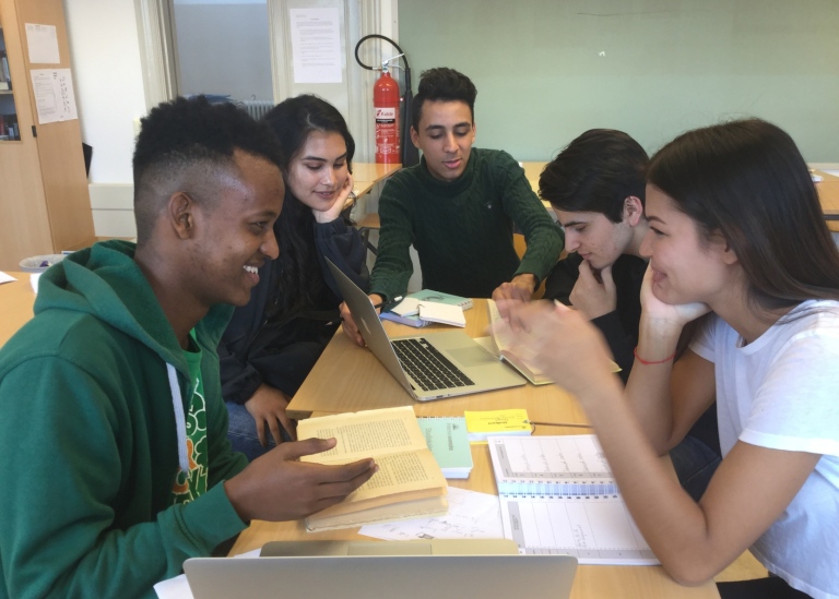 En grupp elever runt ett bord studerar tillsammans. Foto: Intensivsvenska