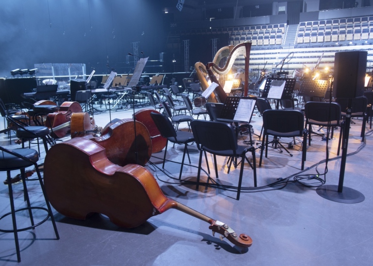 Tom scen med liggande klassiska instrument framför en tom konsertsal.