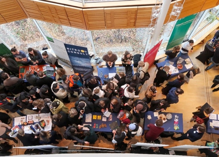 View from above of people at a fair mingling around tables.