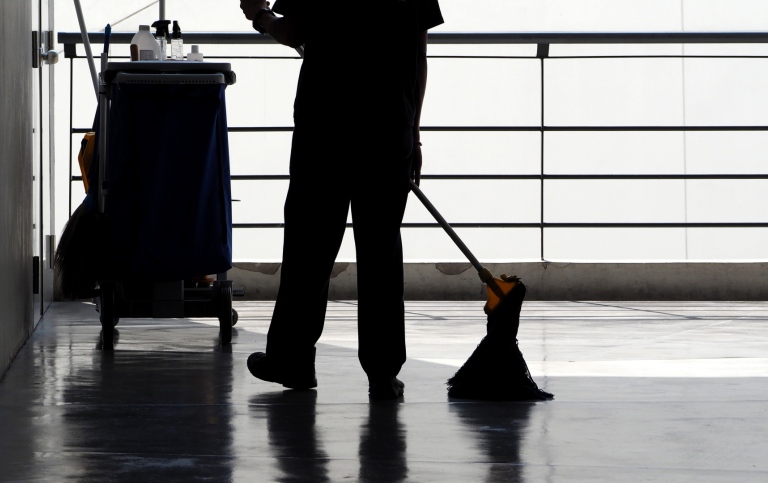 Silhouette of person sweeping floor