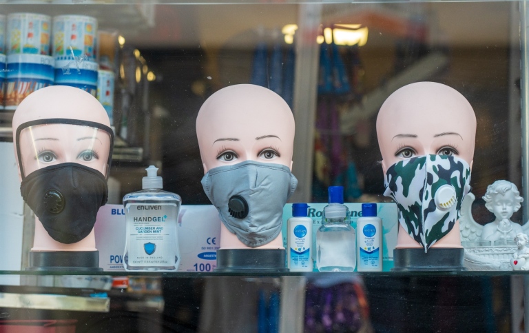 Ett skyltfönster till en butik som säljer munskydd och handsprit