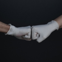 Two hands in gloves, fist bumping