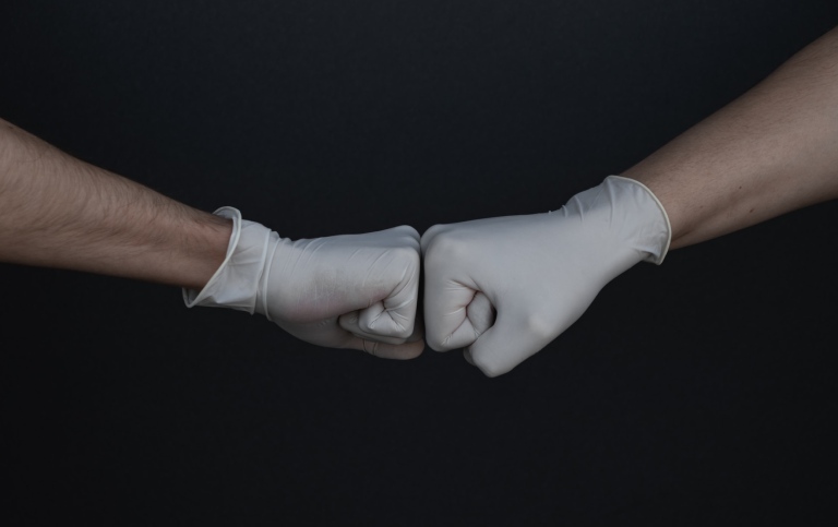 Två händer med handskar som slår nävarna mot varandra