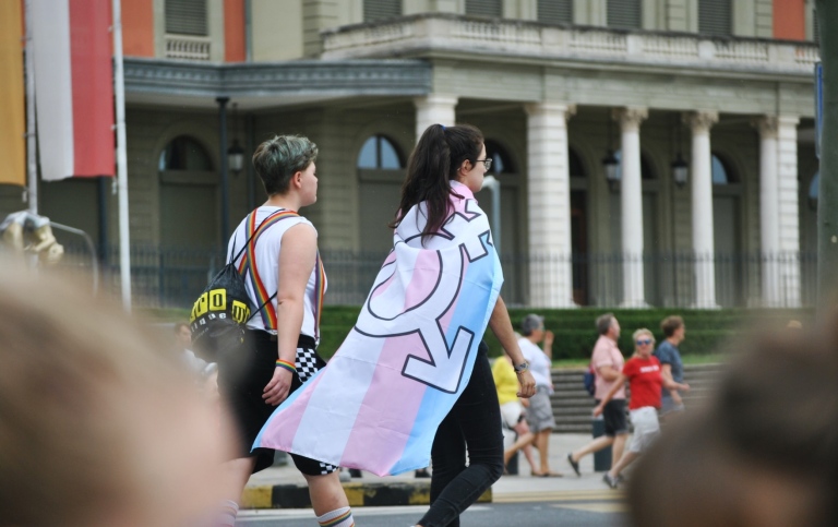 Person som går och bär trans-flaggan