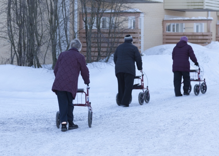 Äldre med rullatorer i snön