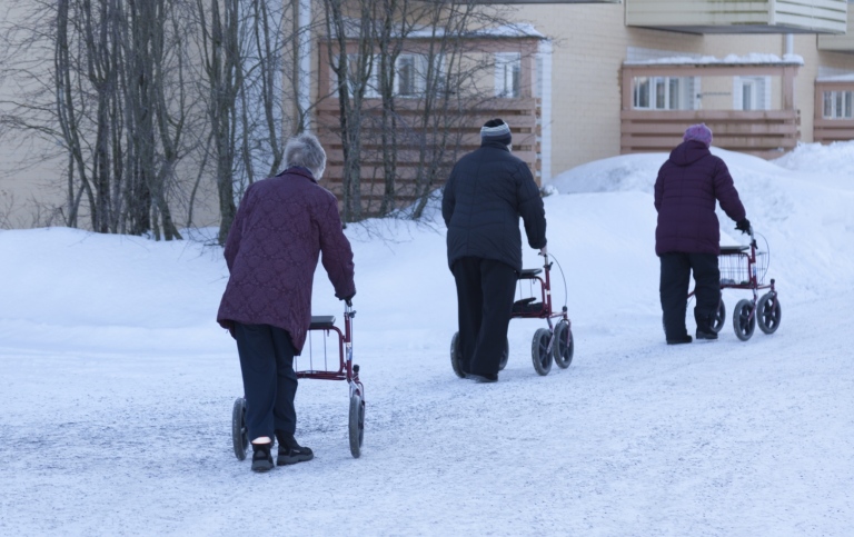 Äldre med rullatorer i snön