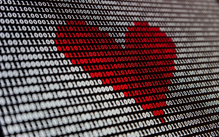 A red heart on a black and white screen background with 1s and 0s.