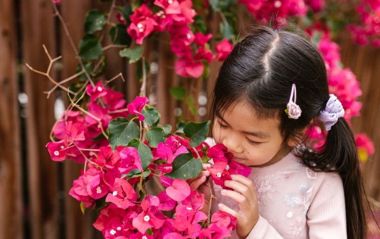 Girl smelling flowers. Photo: RDNE Stock project from Pexels