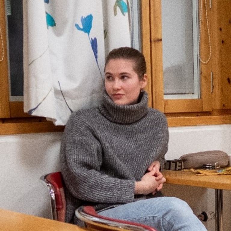 Ung kvinna sitter i ett klassrum.