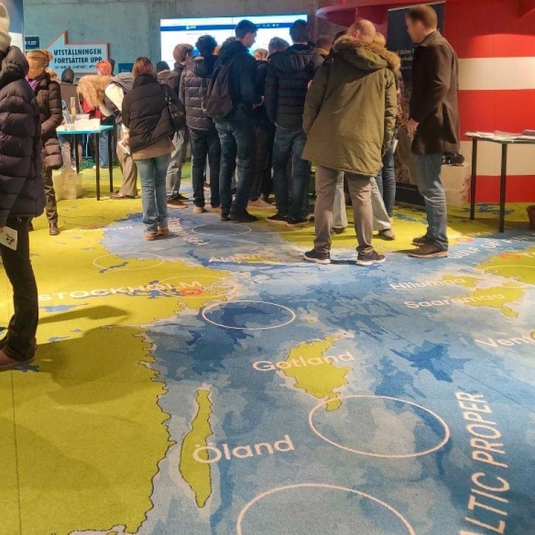 Besökande gymnasieelever på ett golv som ser ut som en karta över Östersjön.