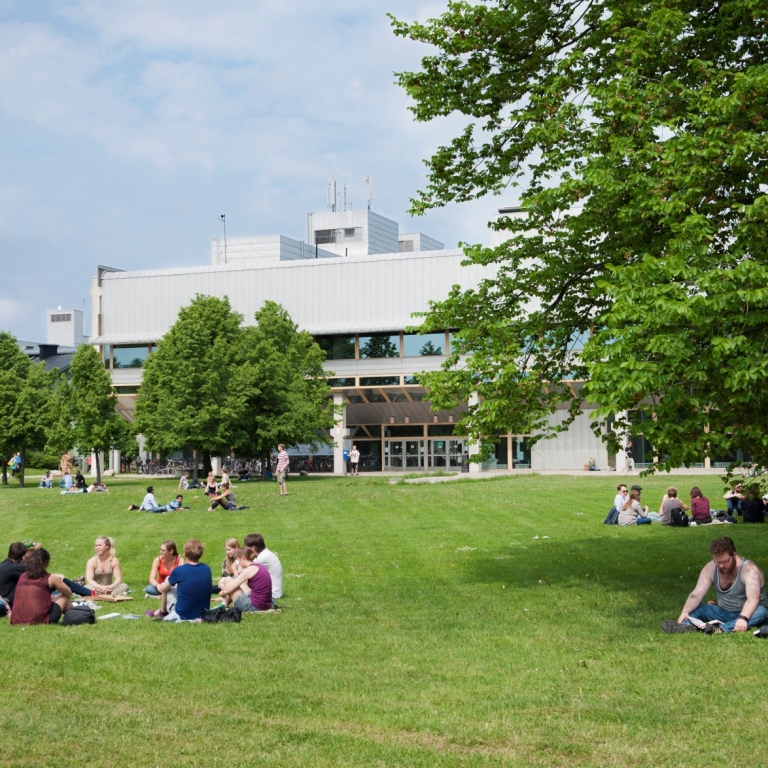 Students on the campus green with the Arrheniuslaboratories in the background. 