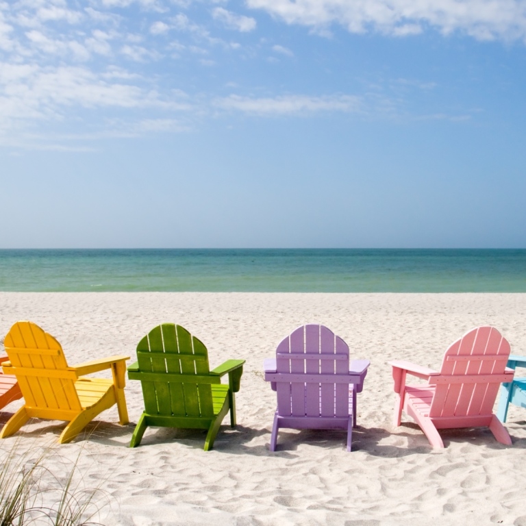 Colourful sun chairs on a beach. 