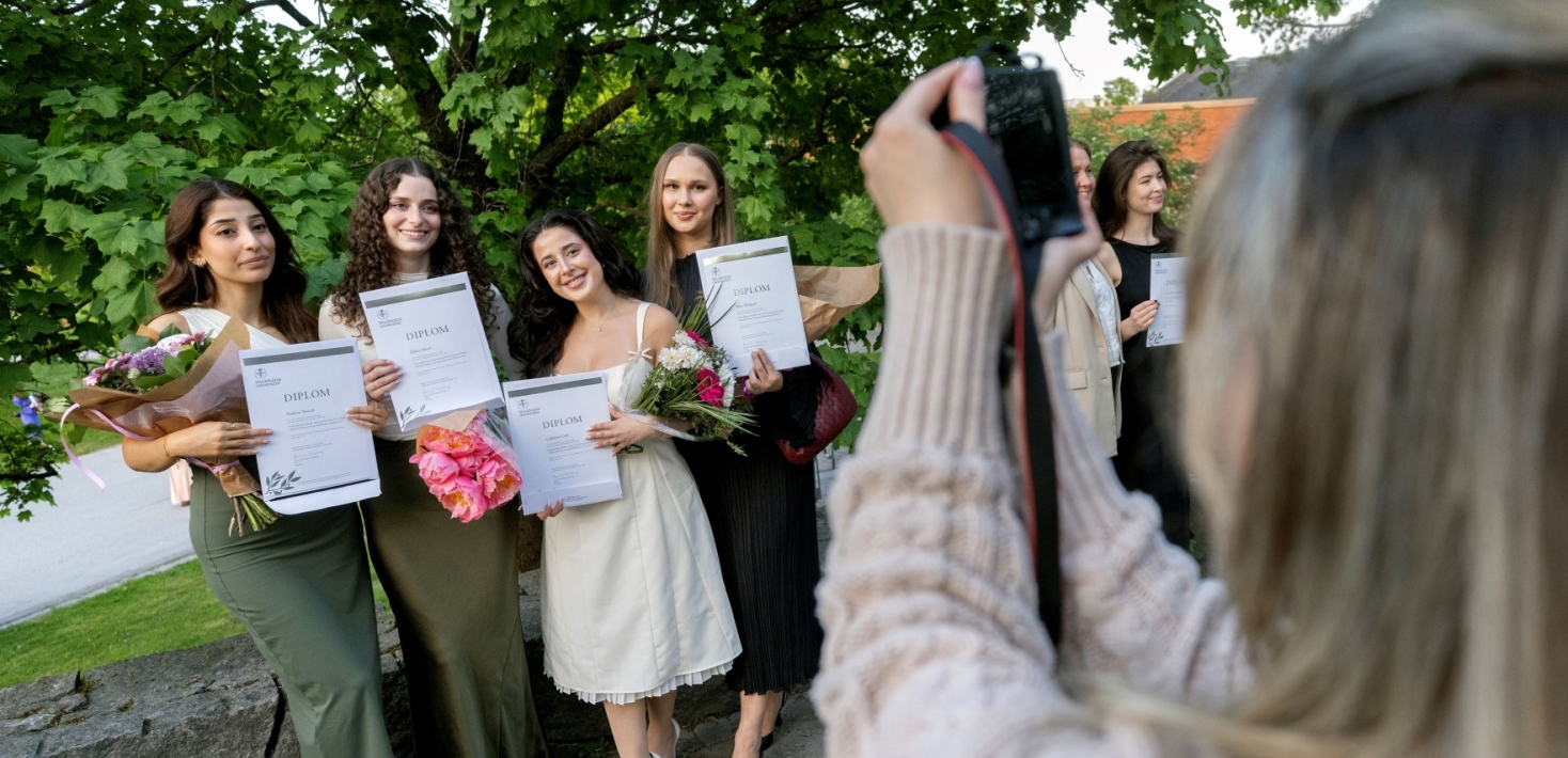 Glada studenter med sina examensbevis vid magisterpromotionen i maj 2024.