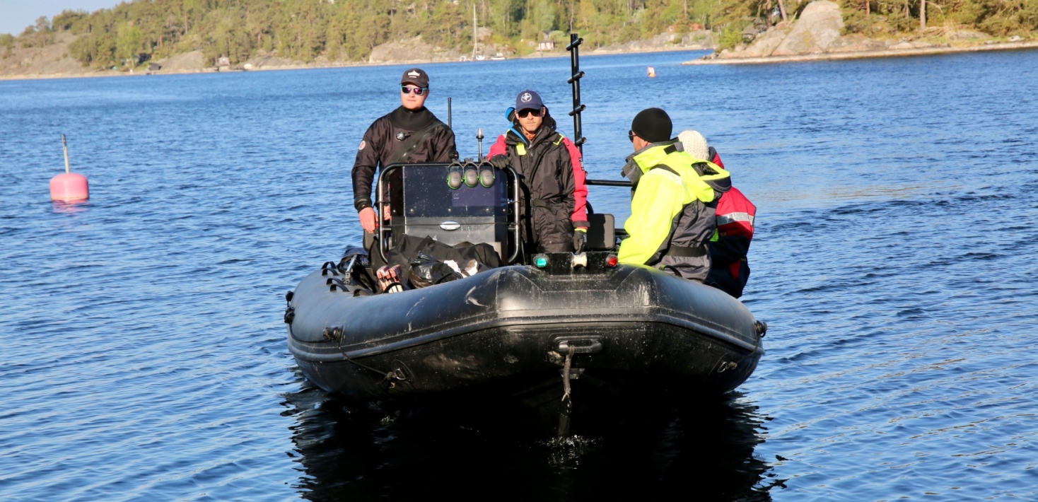 Team members of FORCE sitting in a black rib boat.
